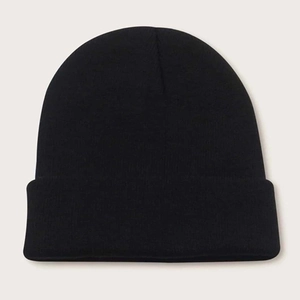 Flat lay of a cuffed black knitted beanie in soft acrylic blend for winter warmth