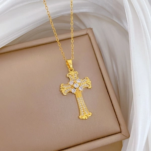 Primo piano di una collana con ciondolo a croce in acciaio titanio e cristalli