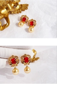 Gros plan détaillé des boucles d'oreilles cœur vintage dorées avec pierres rouges