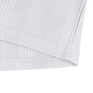 Close-up of jacquard knit polo shirt hem with breathable honeycomb texture and stitching