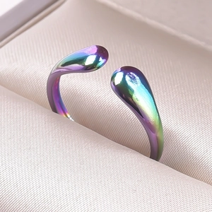 Macro view of iridescent rainbow stainless steel open ring with teardrop ends in a box
