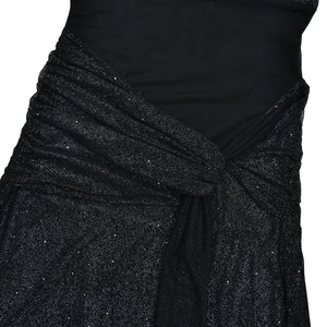 Detail of silver sparkling pleated fabric knot on elegant black slim evening dress