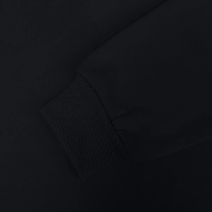 Detail shot of black hooded sweatshirt showing high-quality ribbed knit cuff texture