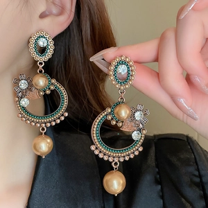 Vintage baroque earrings with champagne pearls and crystals shown on a female model