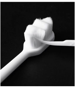 Macro shot of ultra-soft high-density nano bristles on a white manual toothbrush head