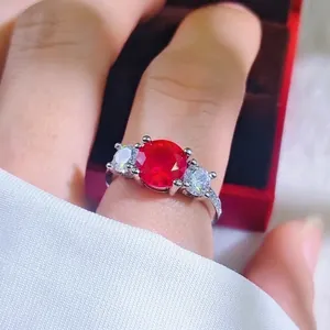 Elegant silver ring with 2-carat red gemstone and side diamonds worn on finger