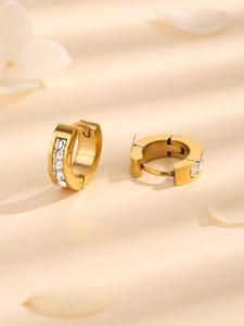 Macro detail of 1.5cm gold huggie earrings featuring four sparkling square-cut zircons