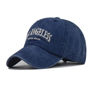 Detail showing white ANGELESS VINTAGE MADE embroidery on navy washed cotton baseball cap