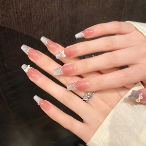 Close-up of pink and blue gradient press-on nails with 3D bows and pearls