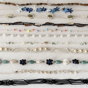 Bohemian braided belt and shell jewelry collection with handmade beads on white texture