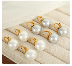 Détails de boucles d'oreilles en perles blanches et grises avec monture dorée élégante