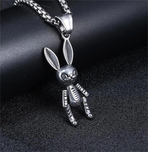 Close-up of silver stainless steel mechanical bunny pendant necklace on black background