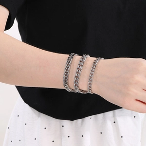 Detailed comparison of three widths of polished silver Cuban chain bracelets on a wrist