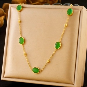 Detailed view of oval green chalcedony and gold beads on a classic necklace in a gift box
