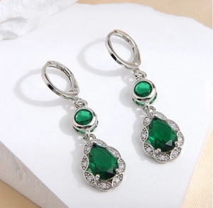 Detail of copper teardrop earrings featuring emerald green zircon and white diamonds