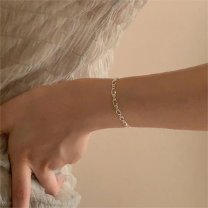 Close-up of minimalist S925 sterling silver geometric link chain bracelet on wrist