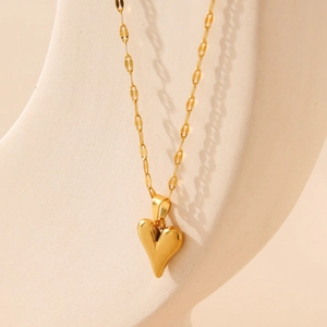Elegant gold stainless steel necklace with 3D heart pendant on geometric stand