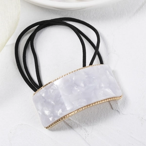 Detail of lavender marble acetate square buckle and gold metal frame on black hair tie