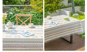 Detail of bohemian linen tablecloth with yellow geometric patterns and white tassels