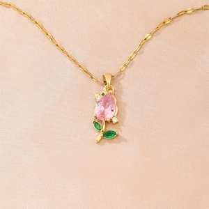 Close-up of tulip flower pendant with pink teardrop zircon and green gems on golden chain