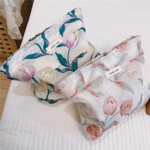 Détail du tissu jacquard à tulipes et étiquette sur les trousses de toilette