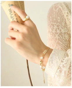 Detail of 18k gold-plated leaf-style bracelet and ring set with lustrous pearls