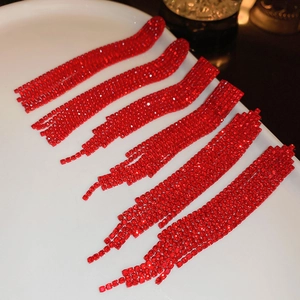Elegant red rhinestone tassel earrings featuring arrow jellyfish design on white ceramic