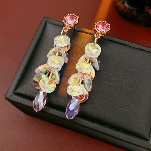 Macro shot of vintage gold earrings with pink gemstones and sparkling crystal tassels