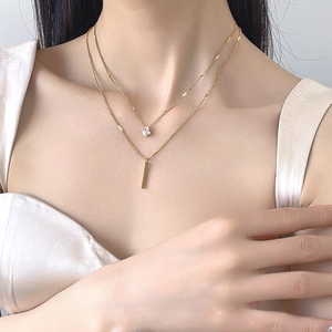 Double-layer gold necklace set with teardrop zircon and vertical bar pendant on model