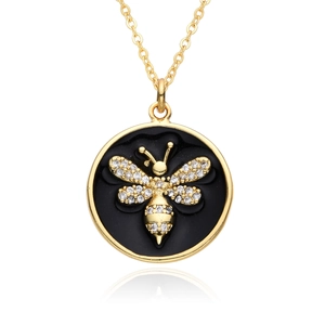 Close-up of gold bee pendant with crystal accents on a circular black background