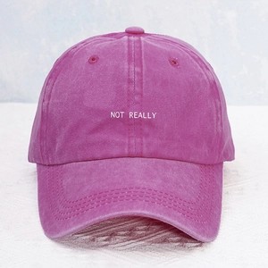 Detailed view of magenta washed cotton baseball cap with white NOT REALLY embroidery
