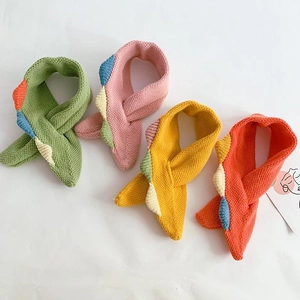 Detailed close-up of soft knitted baby scarves in vibrant colors with cross-over design