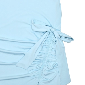 Détail de la robe bleu clair montrant les fronces latérales et le nœud décoratif