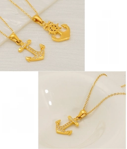 Detail of 18K gold plated anchor and helm pendant necklace with cubic zirconia
