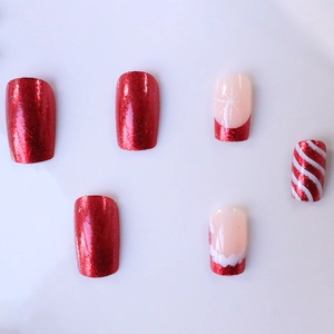 Unghie finte quadrate natalizie con glitter rossi, fiocchi di neve e strisce colorate