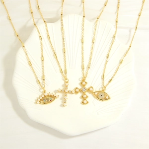 Böhmische Goldhalsketten mit Kreuz- und Augenanhängern auf einer Muschelschale