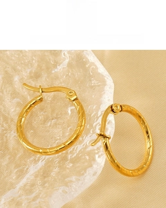 Detail of 18K gold vacuum plated hoop earrings with premium spiral twist texture