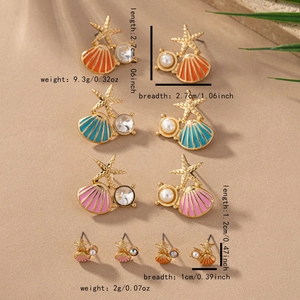 Detailed size measurement of sea star and shell earrings with pearls on sand background