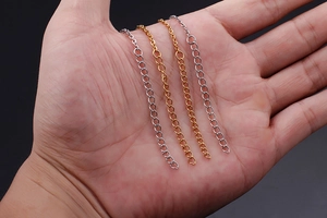 Detail of silver and gold O-chain extension links shown on palm for size comparison