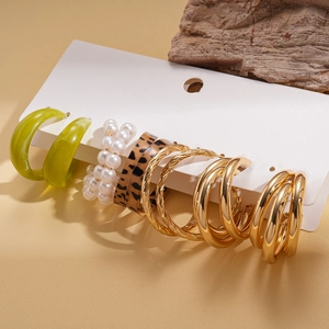 Close-up of 6-pair earring set featuring gold hoops, pearls, and leopard resin on a display card