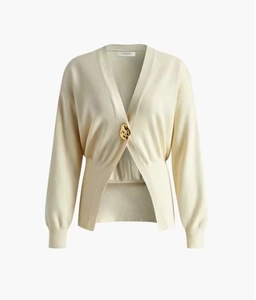 Detailed view of cream knit cardigan featuring a V-neck and a large gold statement button