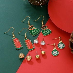 Detail of Christmas earring set featuring snowflakes and reindeer motifs on festive background