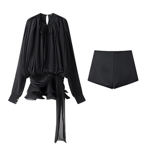 Detail of black pleated long sleeve top and matching shorts two-piece outfit set