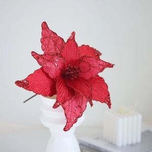 Red artificial poinsettia with sequins in a white vase for Christmas tree decoration