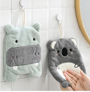 Close-up of soft coral fleece hand towels with cute green hippo and grey koala designs