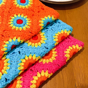 Trois bandanas tournesol au crochet faits à la main empilés sur une table en bois