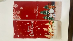 Close-up of decorative Christmas wine bottle bags with festive snowman and Santa prints