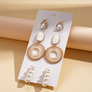 Detailed set of three gold-tone geometric earrings with faux pearls on white card