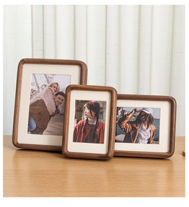 Three-piece walnut wood photo frame set with rounded corners in a home setting
