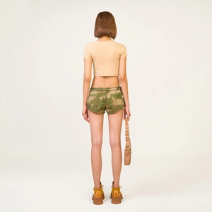 Detail view of the green camouflage tie-dye cargo shorts and cropped tank top back view